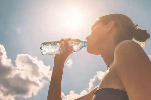 Hydration: The Secret Ingredient for a Toned Stomach and Enhanced Fitness 3 Image of woman drinking water to hydrate Hertfordshire after run.